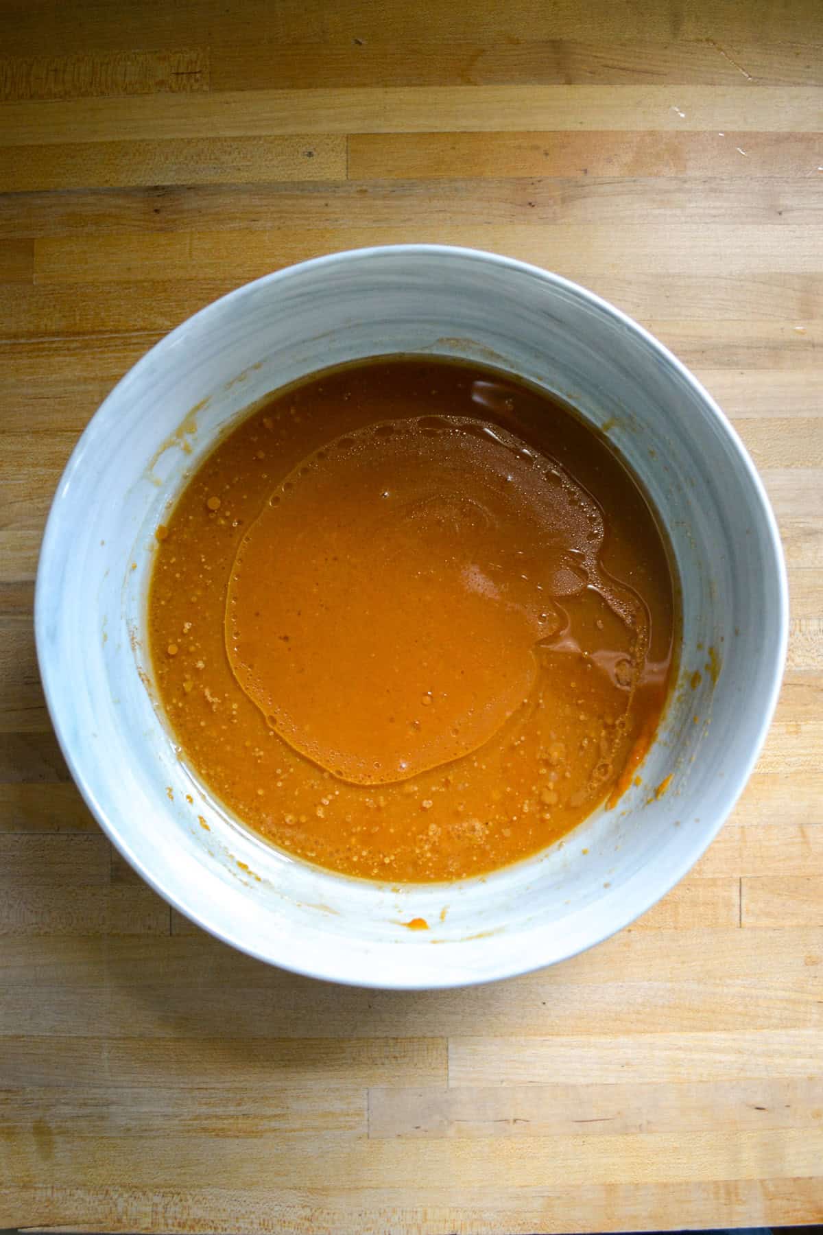 The wet ingredients for the cake in a large mixing bowl.