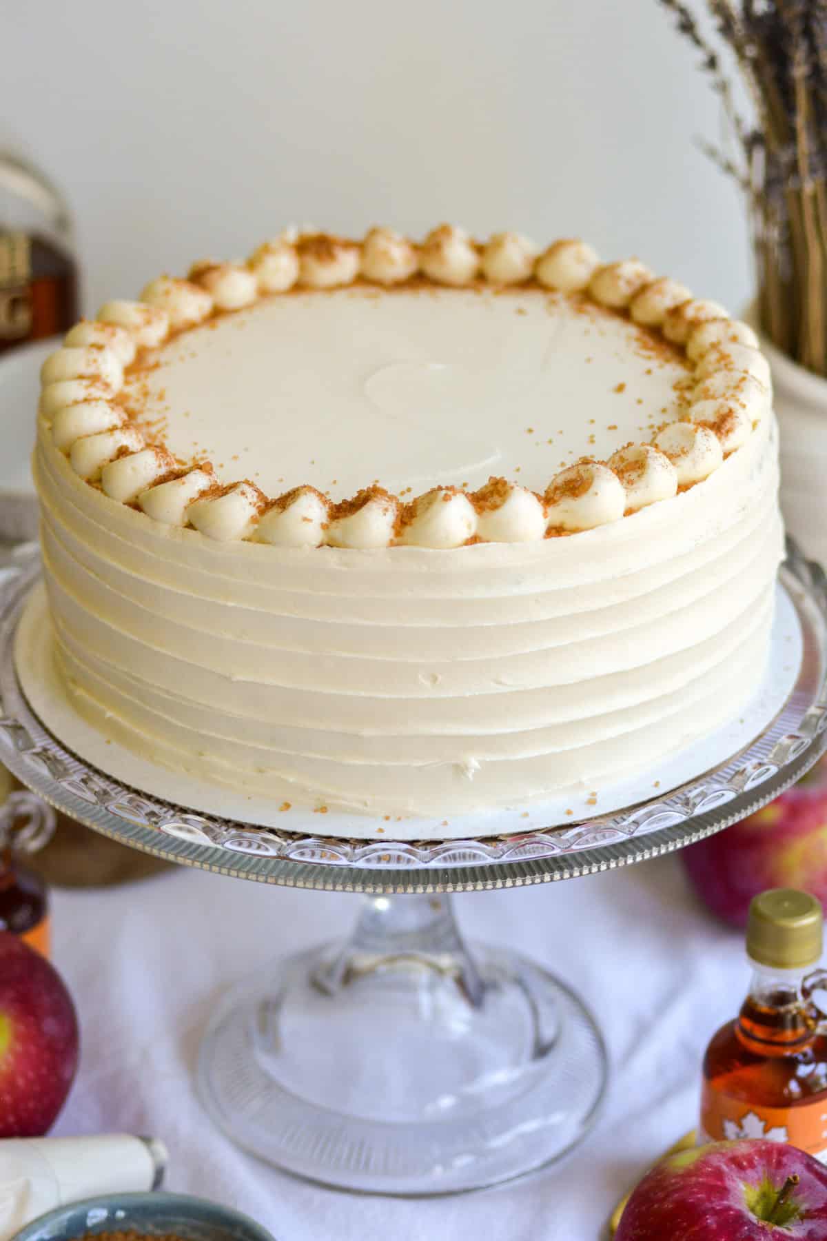 A Vegan Apple Cake on a glass cake stand.