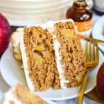 A slice of Vegan Apple cake on a plate with a gold fork.