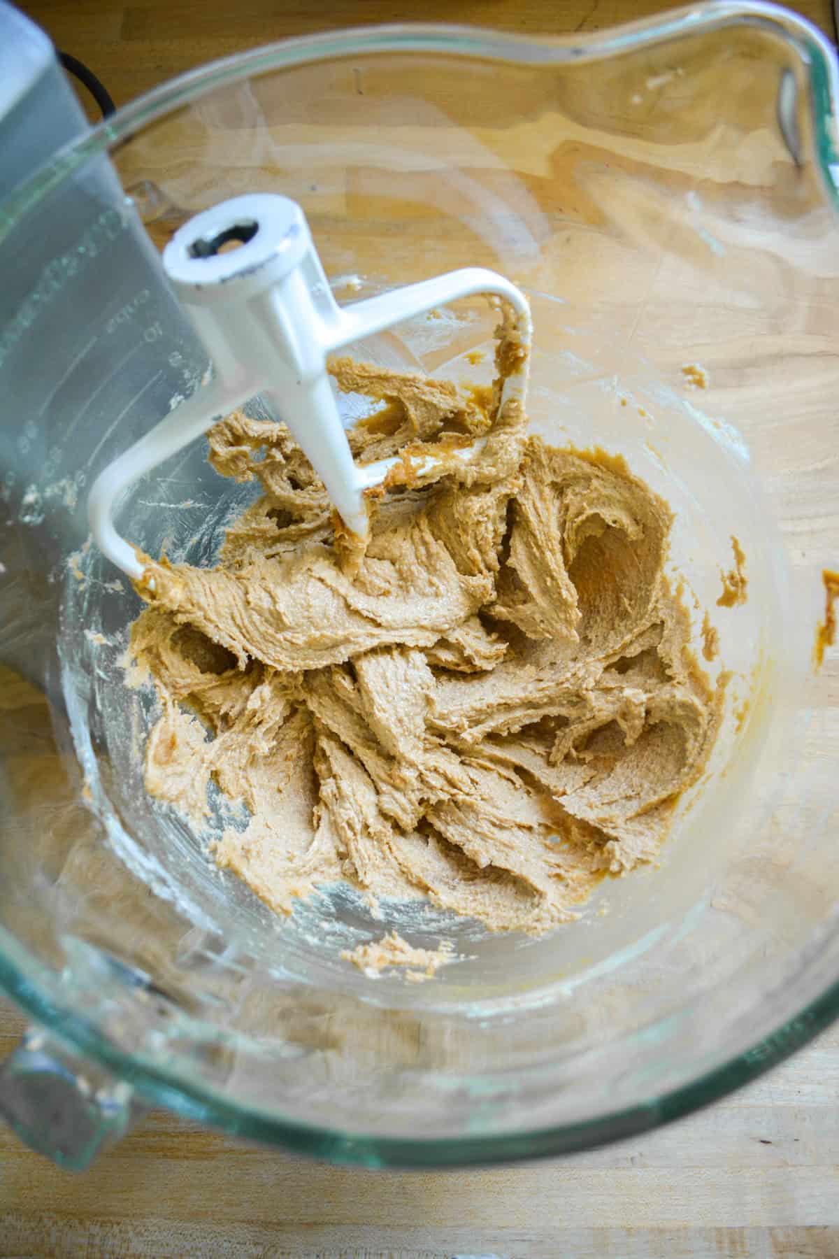 Butter, Biscoff spread and brown sugar creamed together in a glass mixing bowl.