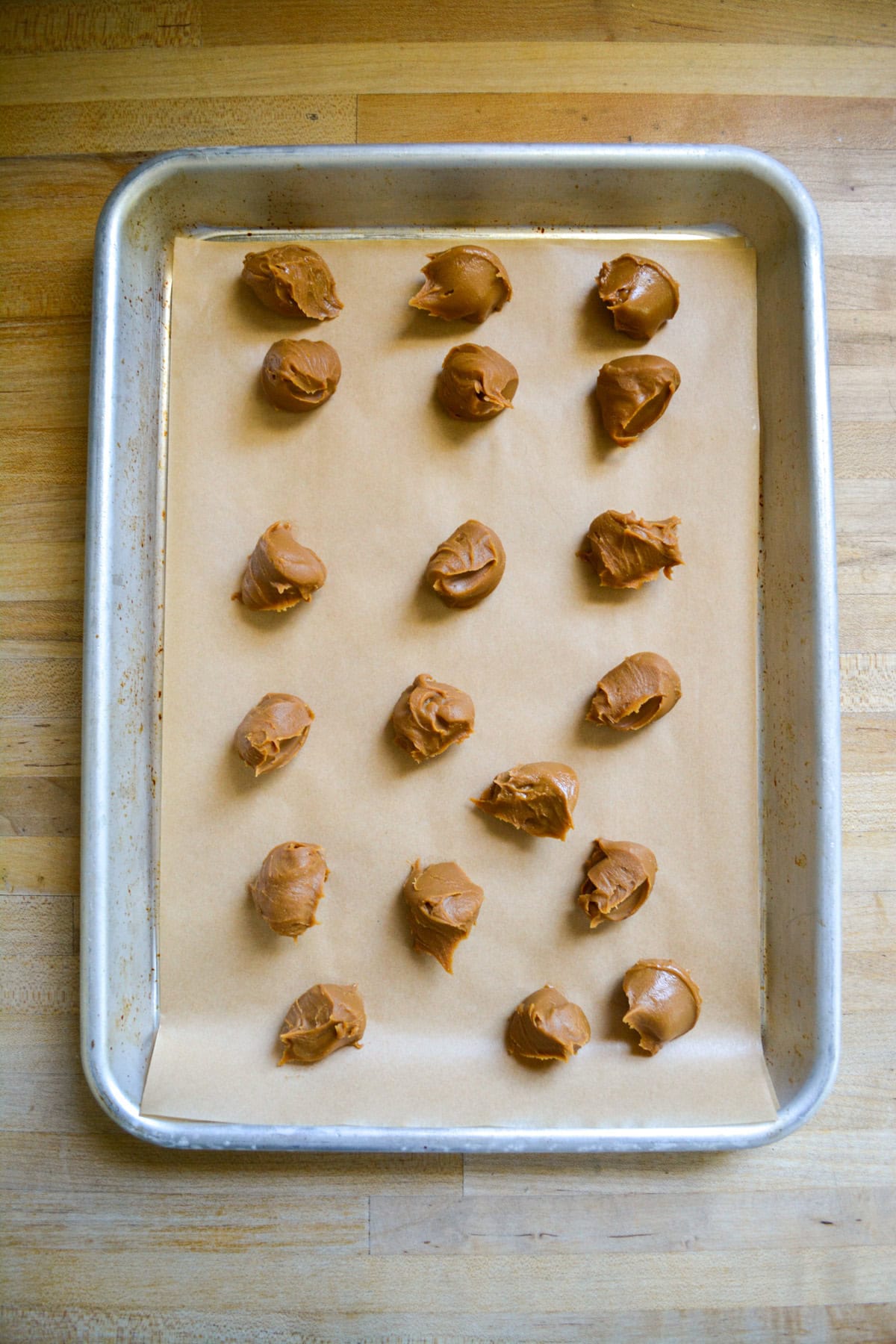 Biscoff Cookie Butter balls scooped onto a parchment-lined baking sheet.