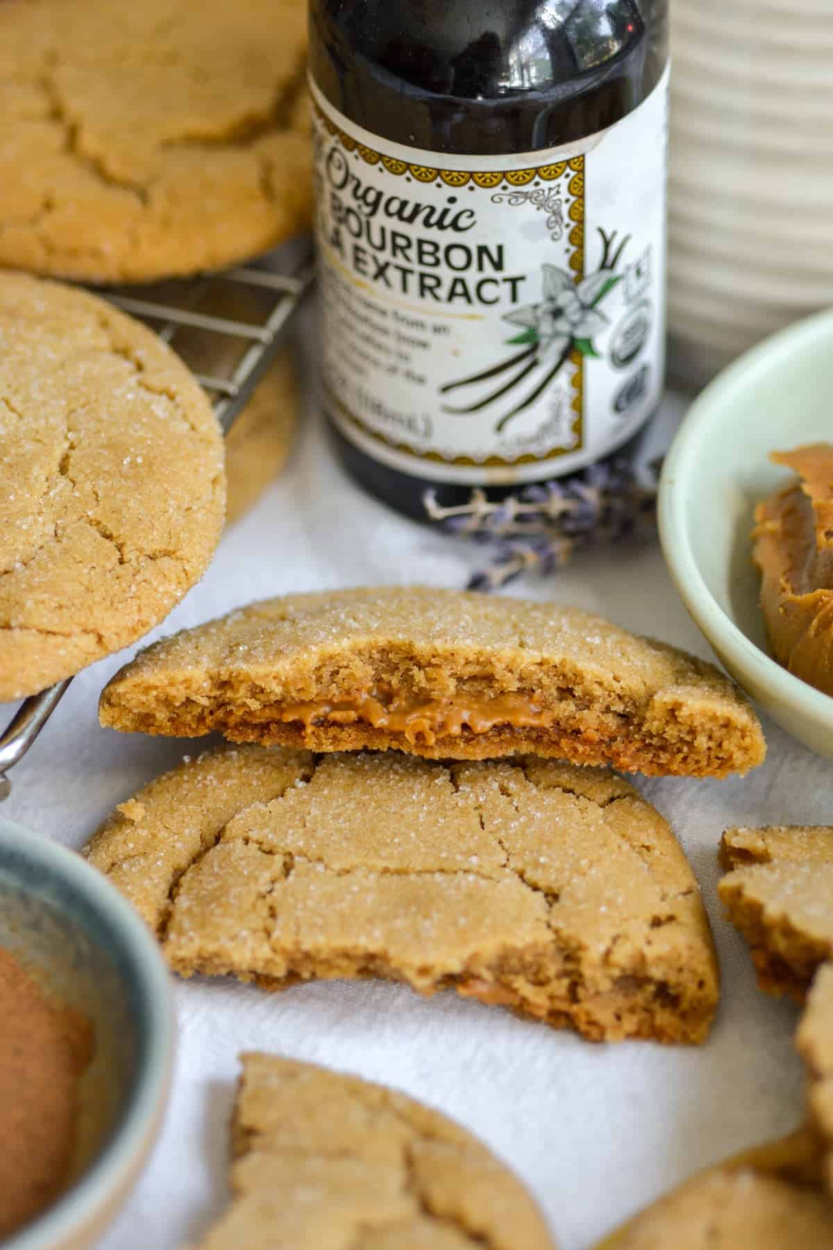 A Vegan Biscoff Stuffed Cookie broken in half to show the gooey interior.
