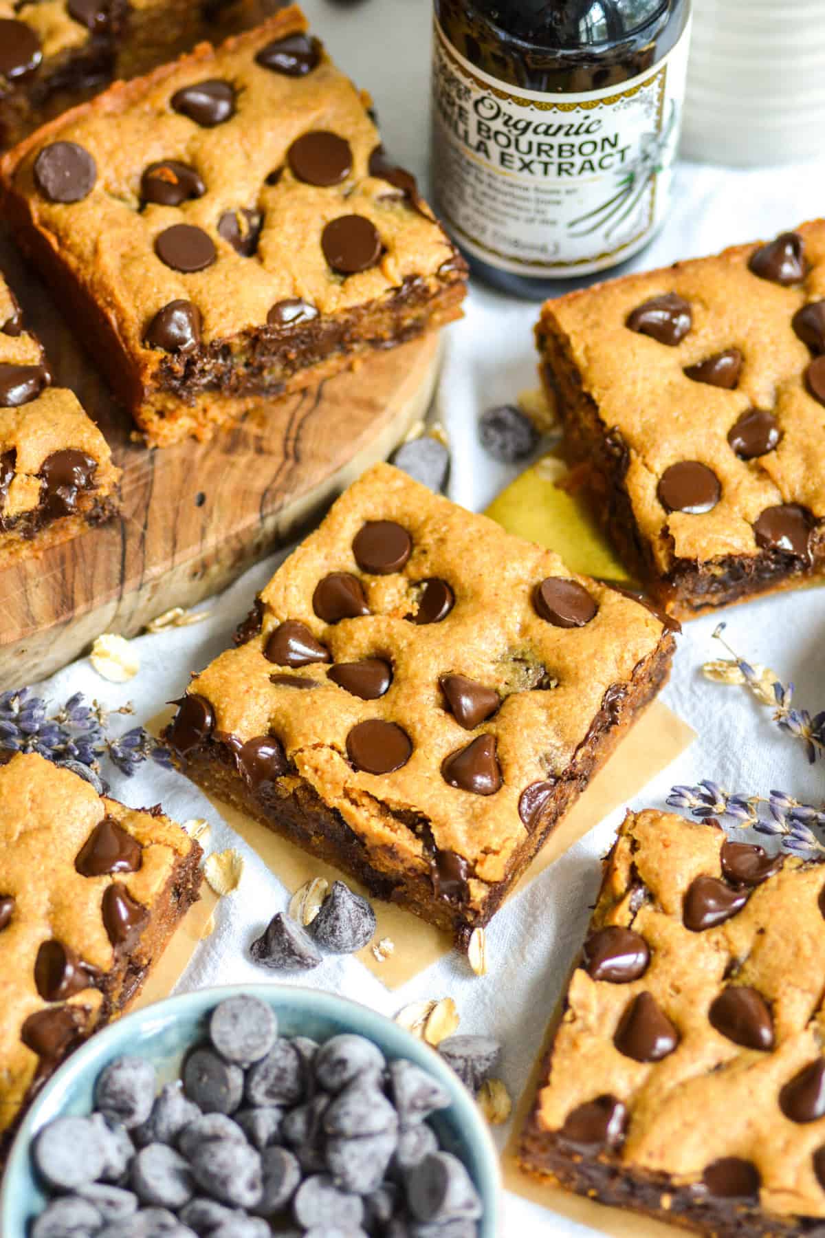 Gluten-Free Peanut Butter Blondies on a linen surface next to a bowl of chocolate chips.